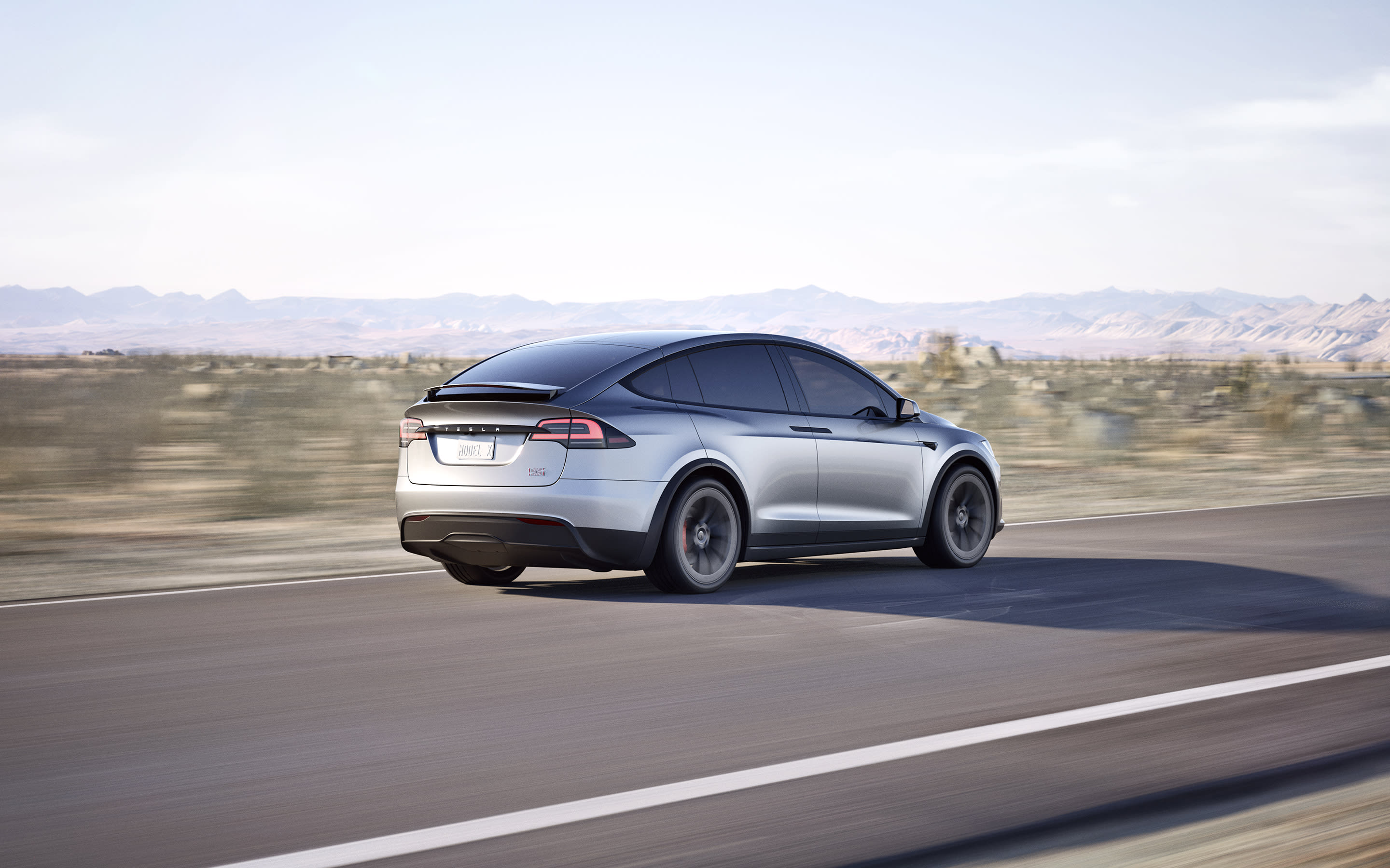 Pearl white Model X navigating a mountainous road